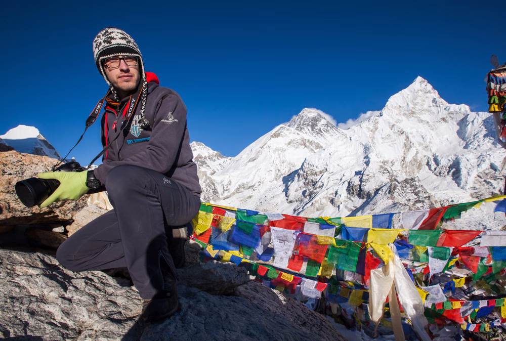 Tibetan flag waving and a man with helment resting
